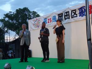 ルーイスさんと坂本さんと壇上で話をする平井一三市長