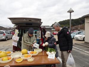 朝市でお買い物をする平井一三市長