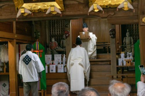 粥箱を取り出す神職の写真