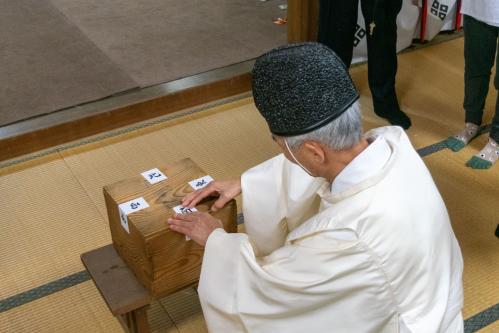 粥箱の封印を解く神職の写真