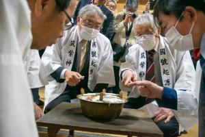 粥の表面を確認する5人の判断員